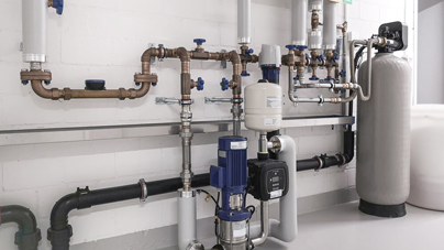 Moderne Heizungsanlage im Technikraum mit Pumpen, Rohrleitungssystem und hydraulischer Weiche - Professionelle Heizungstechnik