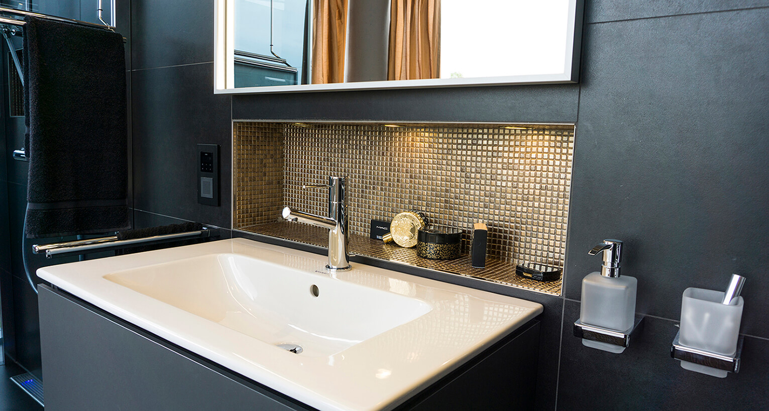Modernes Badezimmer-Waschbecken mit goldener Mosaikfliesen-Nische, schwarzer Wandgestaltung und Designer-Armatur