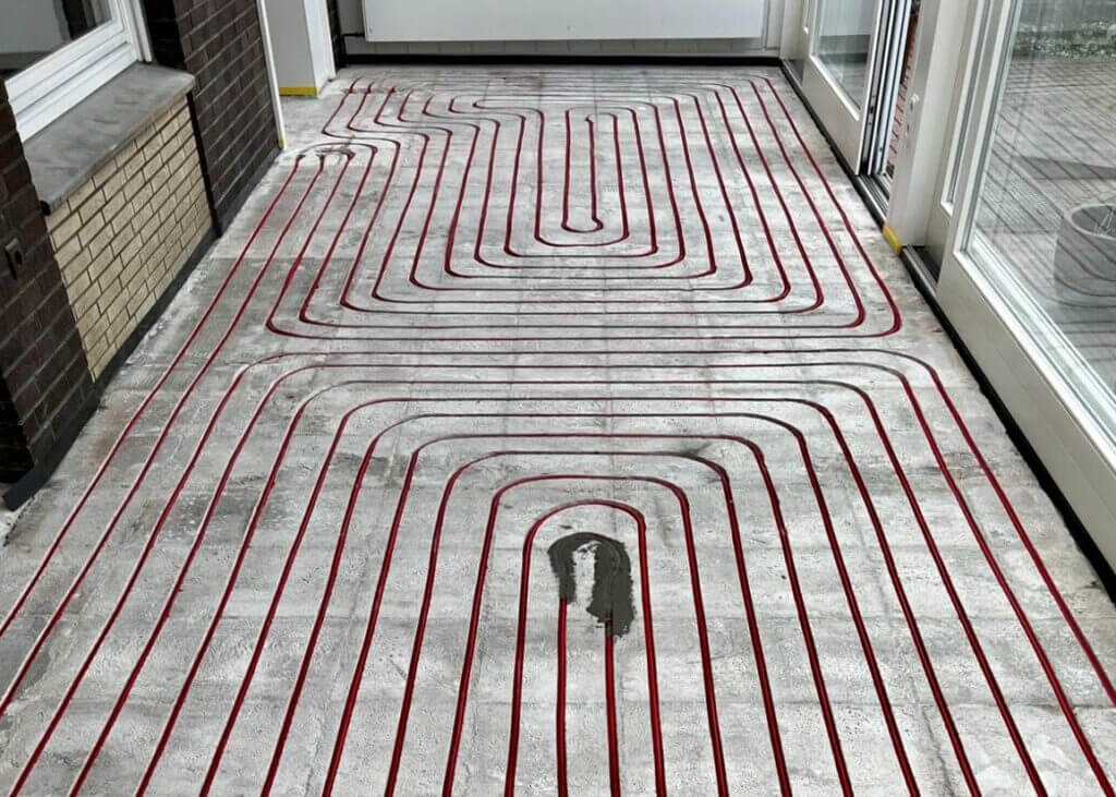 Wand- und Fußbodenheizung Installation - Professionelle Verlegung der roten Heizungsrohre für effiziente Flächenheizung.