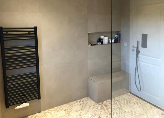 Bodenebene Dusche mit Ornamentfliesen, schwarzem Handtuchheizkörper und eingebauter Wandnische - Barrierefreies Baddesign